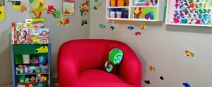 Ein Spielzimmer für 8-jährige Kinder mit einem bunten Stuhl und Büchern.