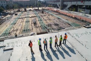 Eine Gruppe Bauarbeiter steht auf einer Baustelle.