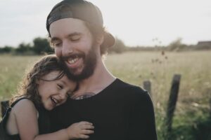 Ein Mann mit Bart und ein kleines Mädchen auf einem Feld.