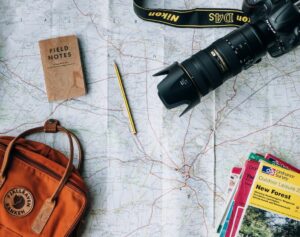 Ein Rucksack, eine Kamera, eine Karte und andere Gegenstände auf einer Karte.