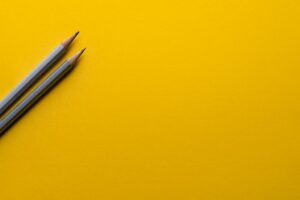 Zwei Bleistifte auf gelbem Hintergrund.